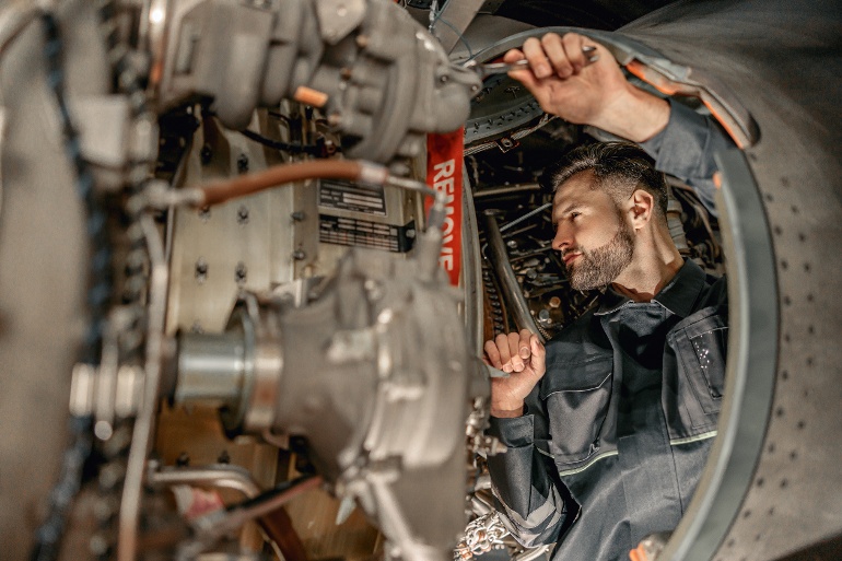 bearded-man-mechanic-repairing-aircraft-hangar-1